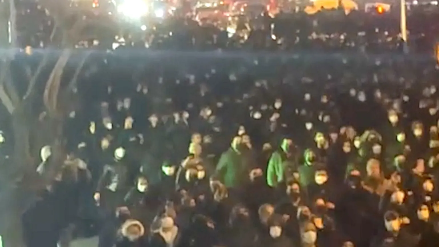 德黑兰卡沙尼地区夜间集会 人群戴口罩与兜帽