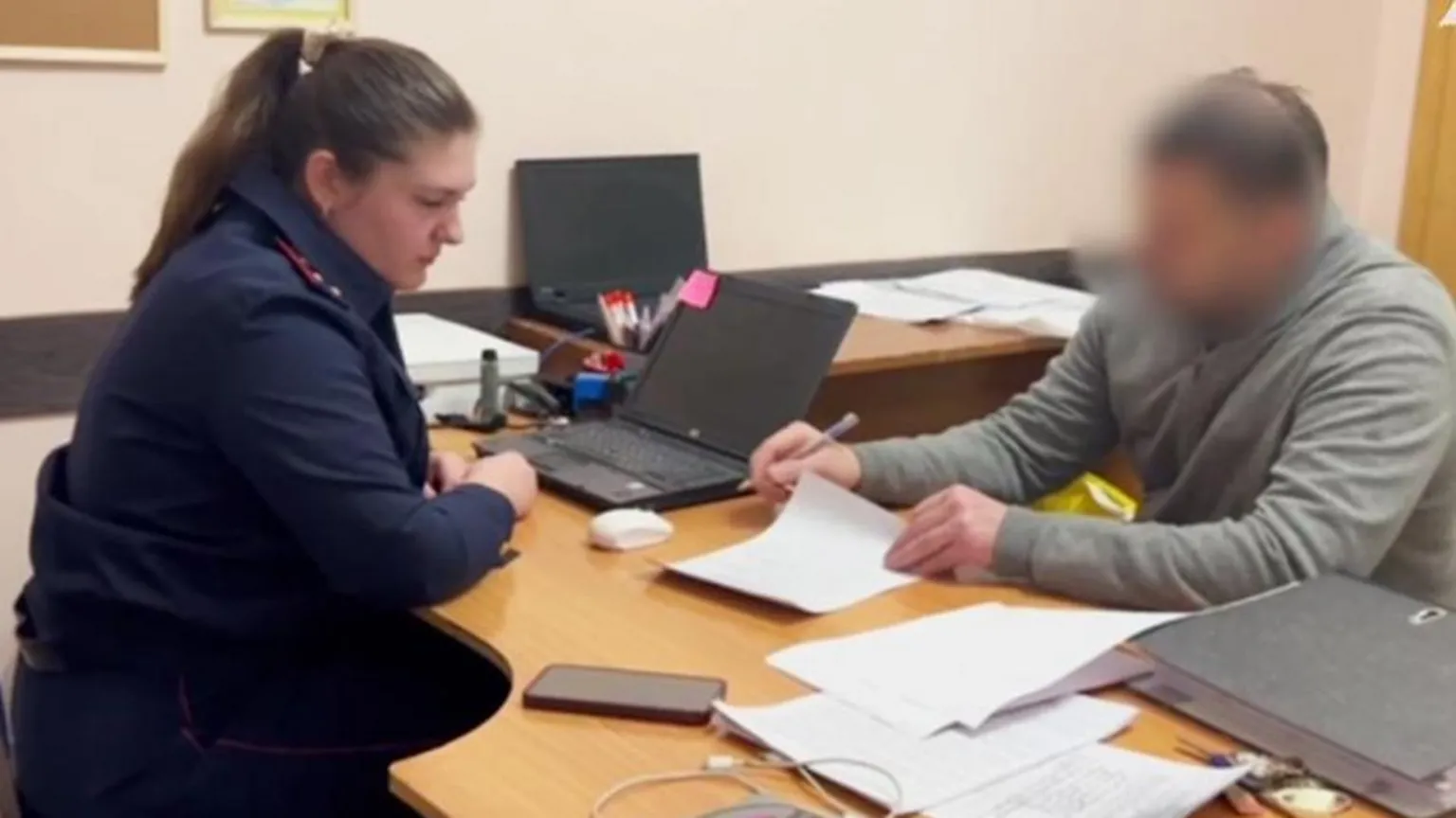 警方调查人员与一名被拘医生在桌前交谈