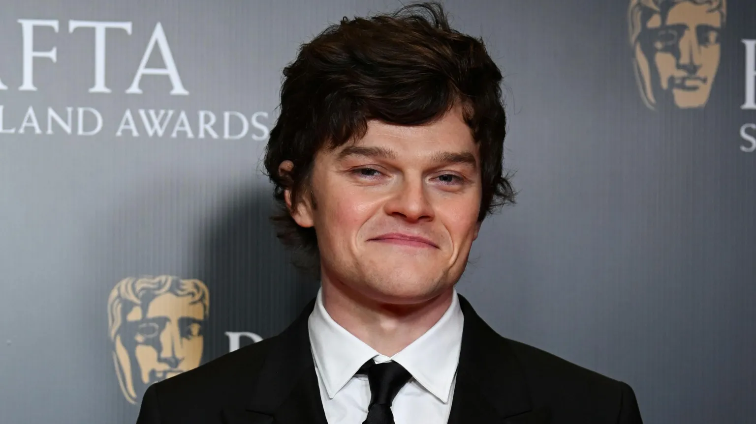 罗伯特·阿拉马约身穿黑色西装在红毯上摆姿势