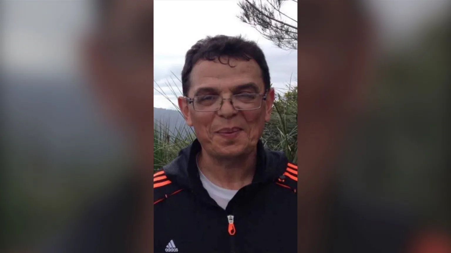 Leia Roitour Boris Tetleroyd wearing glasses and dressed in a black shirt with bright orange stripes on the shoulders.