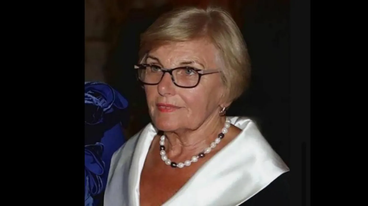 Handout Marika Pogany wearing a cream collared blouse with a pearl necklace and wearing glasses